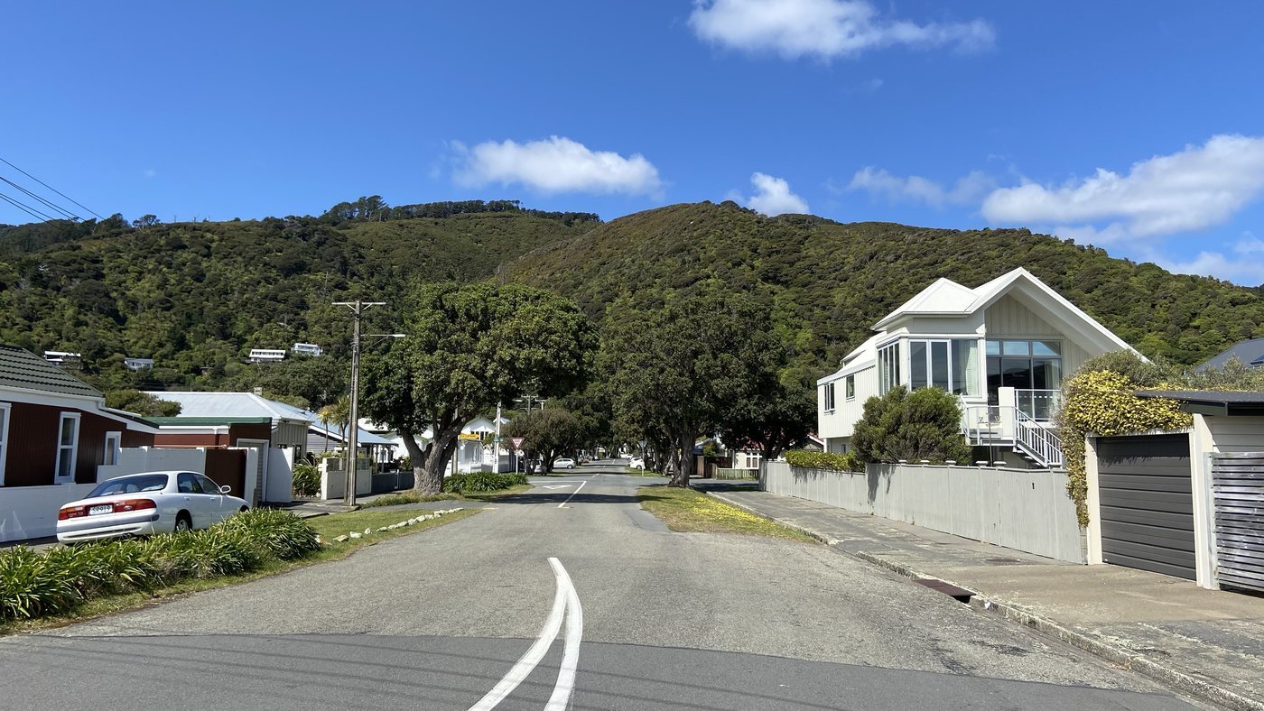 A suburban street with hills behind it